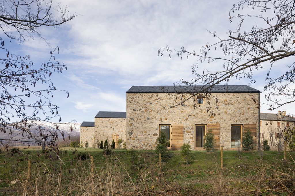 Construcción con estructura de madera, fachada en piedra y cubiertas de pizarra