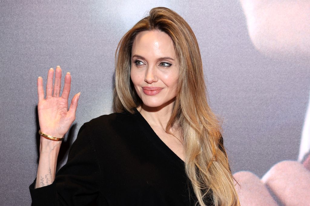 Plano medio de Angelina Jolie con jersey negro de cuello pico