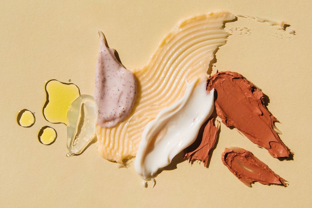 Texturas cremas, sérums, mascarillas sobre fondo amarillo