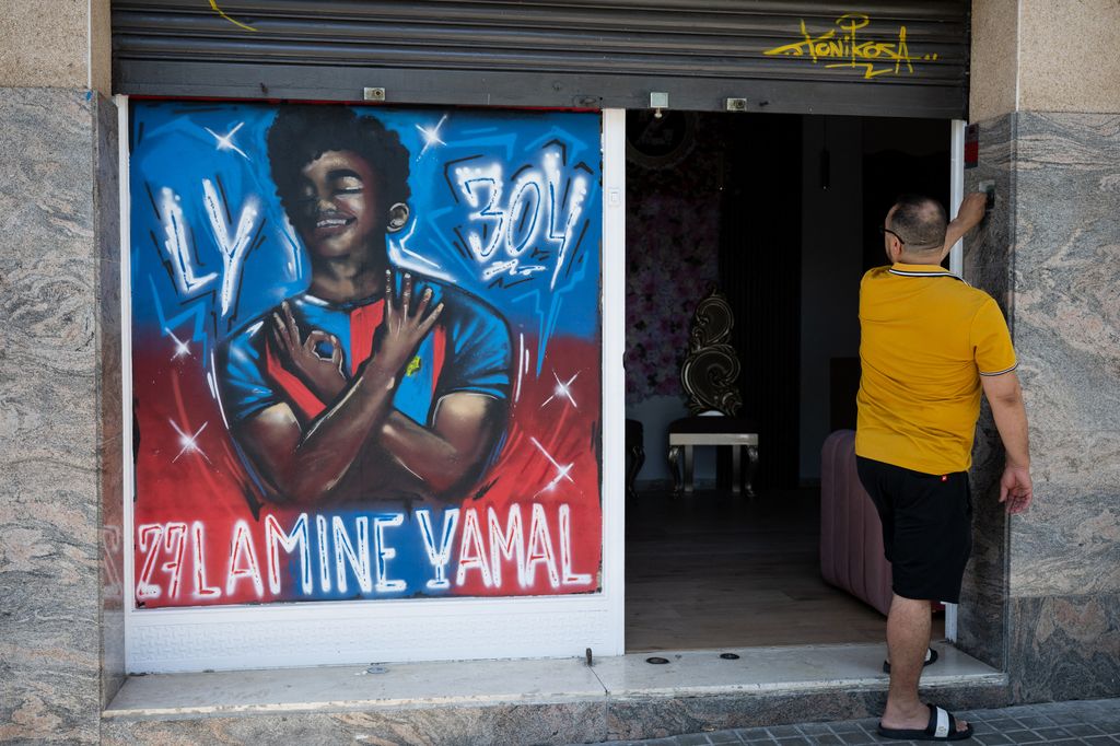 Un hombre observa un grafiti que representa a Lamine Yamal en Rocafonda, el barrio donde creció el delantero español, en Mataró (a 35 km de Barcelona), el 11 de julio de 2024. Cada vez que marca un gol, Lamine Yamal suele hacer el gesto del número 304 con las manos. Es el código postal del humilde barrio catalán donde pasó parte de su infancia, Rocafonda, que ahora vive con gran ilusión su éxito y el hecho de aparecer finalmente en las noticias por motivos positivos.