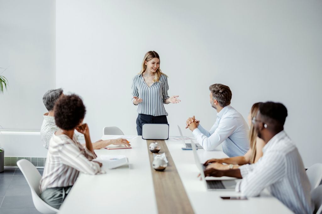 mujer en la oficina, hablando con su equipo