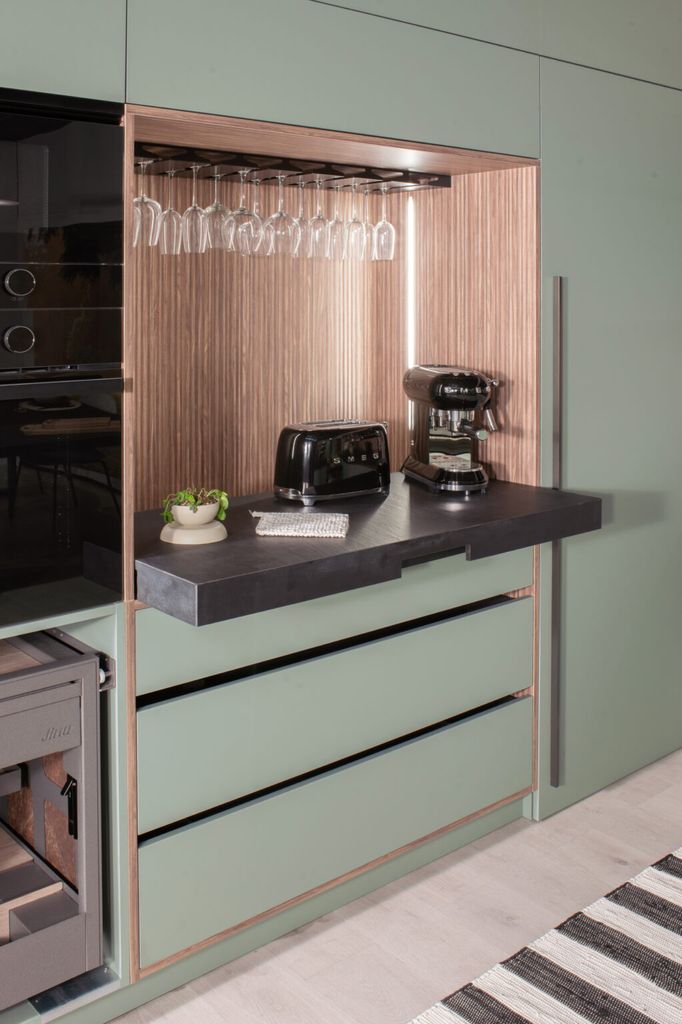 Cocina verde con desayunador abierto en madera
