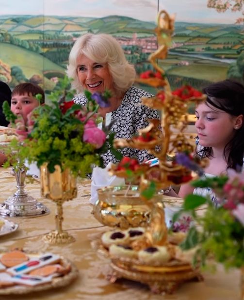 La Reina y los dos niños, tomando el té