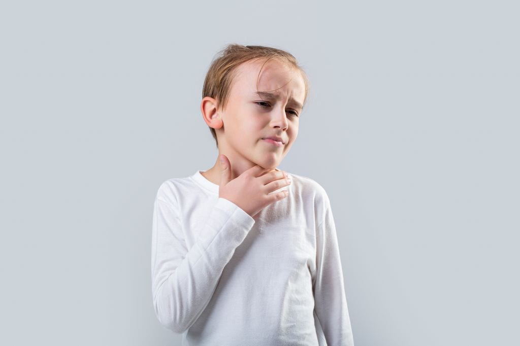 Niño atragantándose con la mano en la garganta