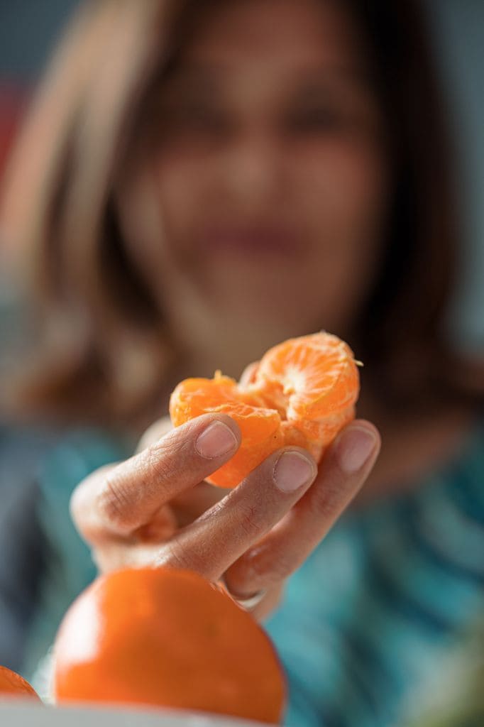 Una mujer pelando una mandarina