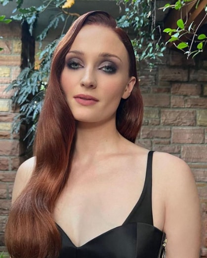 Primer plano de Sophie Turner con melena cobriza y maquillaje de ojos