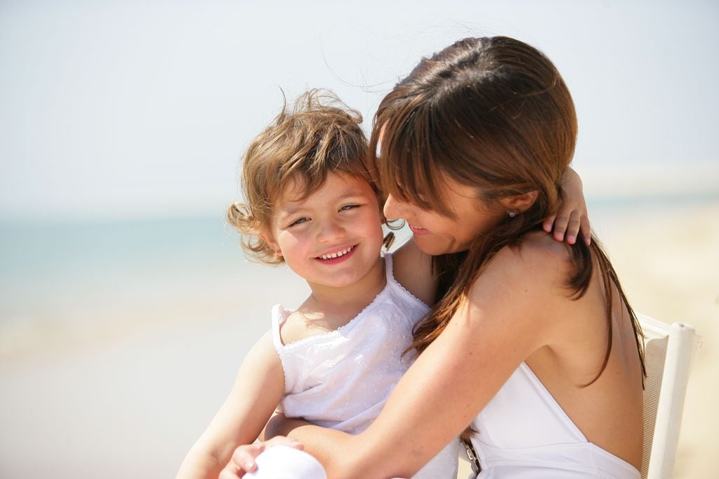 Madre con su hija feliz en la playa