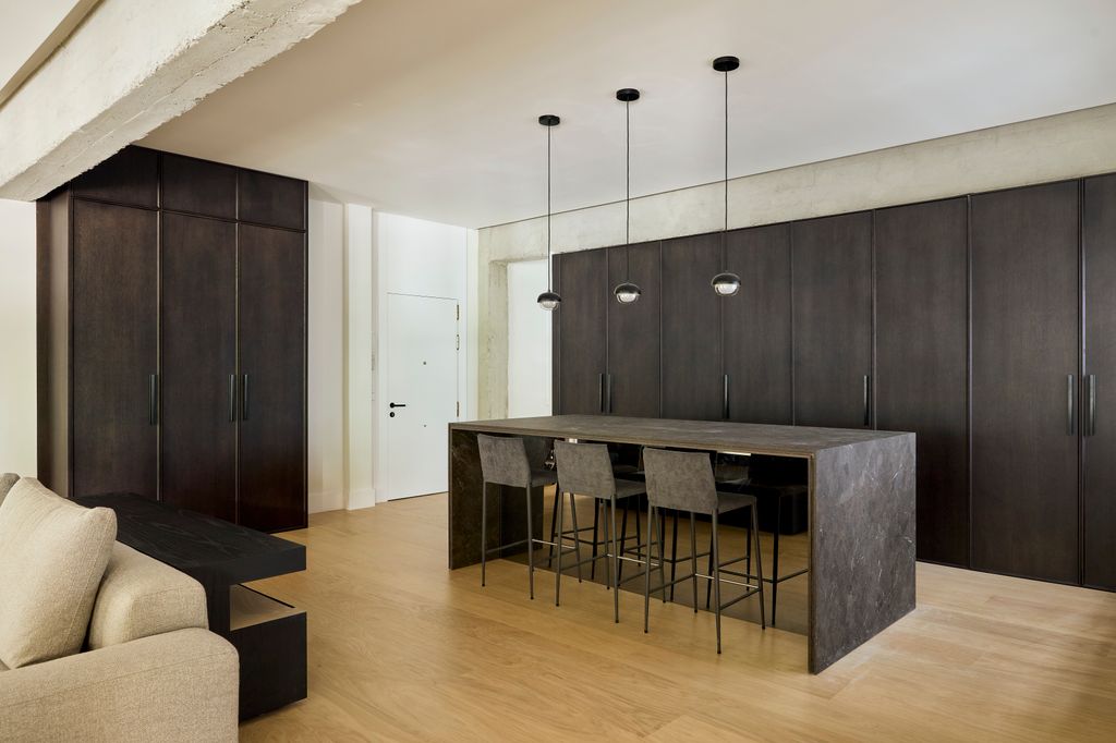 Cocina abierta decorada con muebles de madera oscura