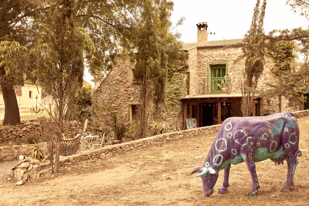 Una vaca pintada en la fachada de la farmacia de Macarena Gómez y Aldo Comas en el Alto Ampurdán