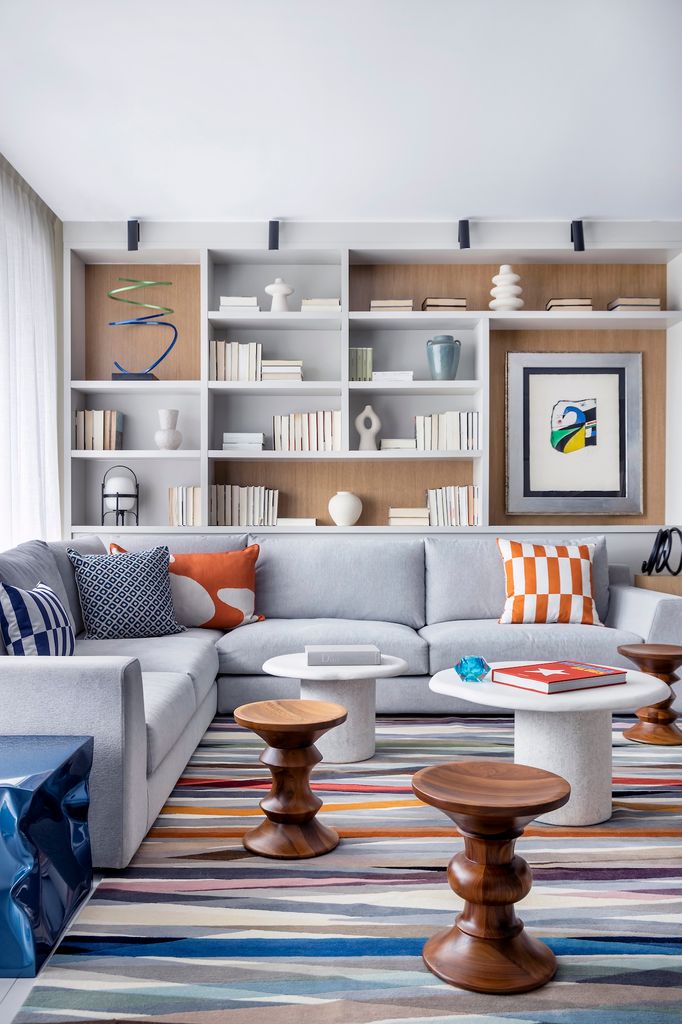 Salón con sofá gris y textiles en azul y naranja.