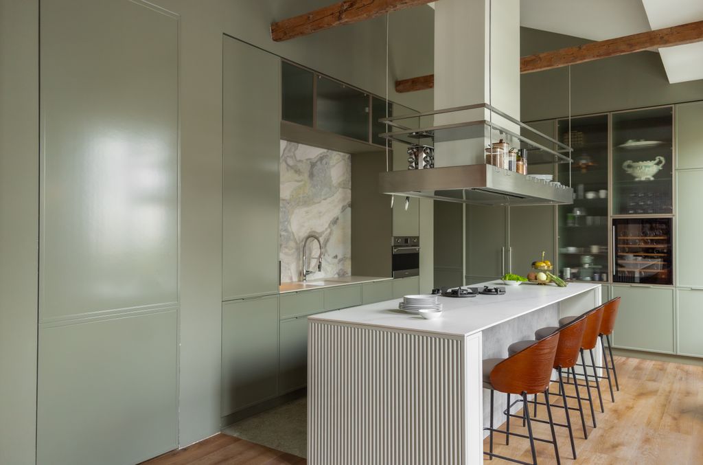Cocina con isla central que alberga zona de cocción y una barra