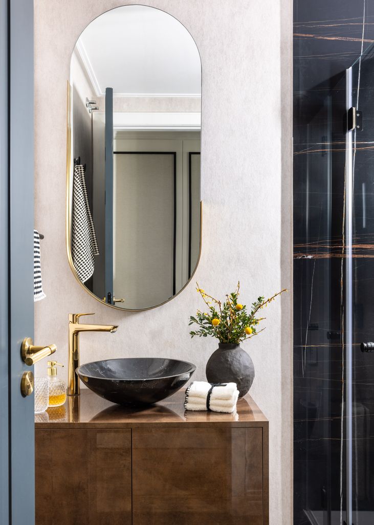 Baño moderno con espejo ovalado. 