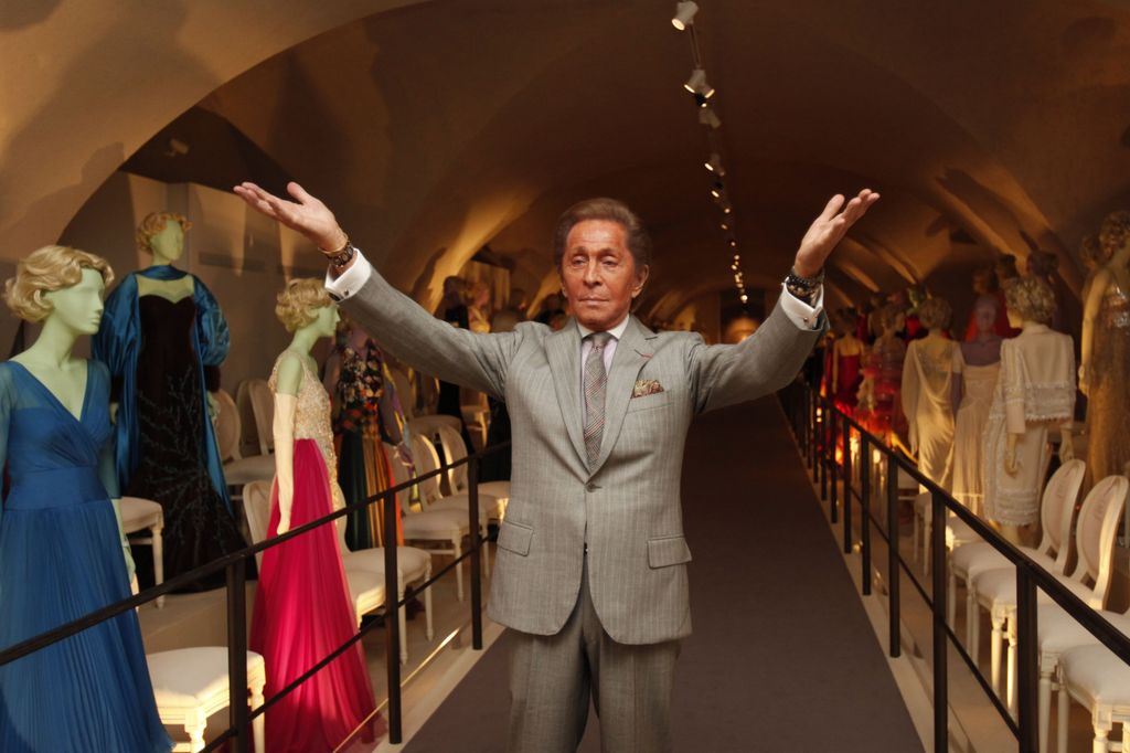 El diseñador Valentino  junto a algunas de sus creaciones 