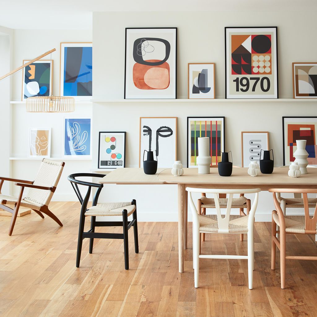 Pared decorada con composición de láminas en baldas