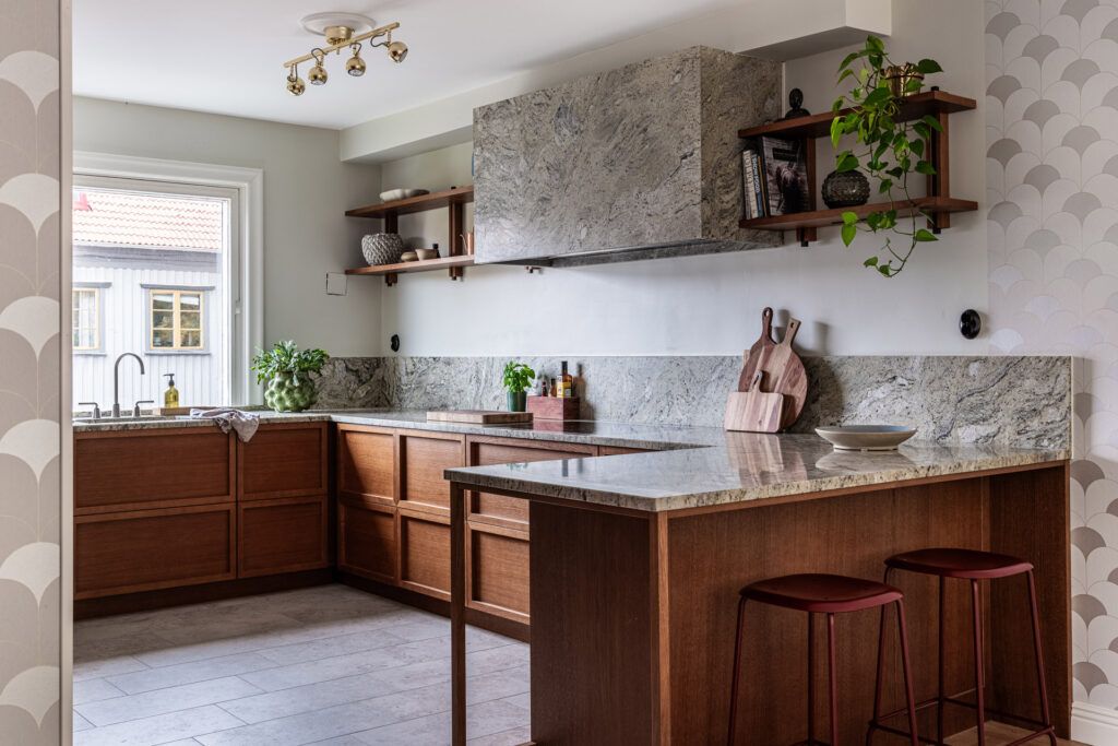 Cocina con mobiliario en madera y encimeras de piedra