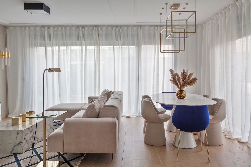 Sillas de comedor la misma familia, aunque no idénticas. En la cabecera con patas y tapicería azul eléctrico y en los laterales, un solo pie y de color neutro