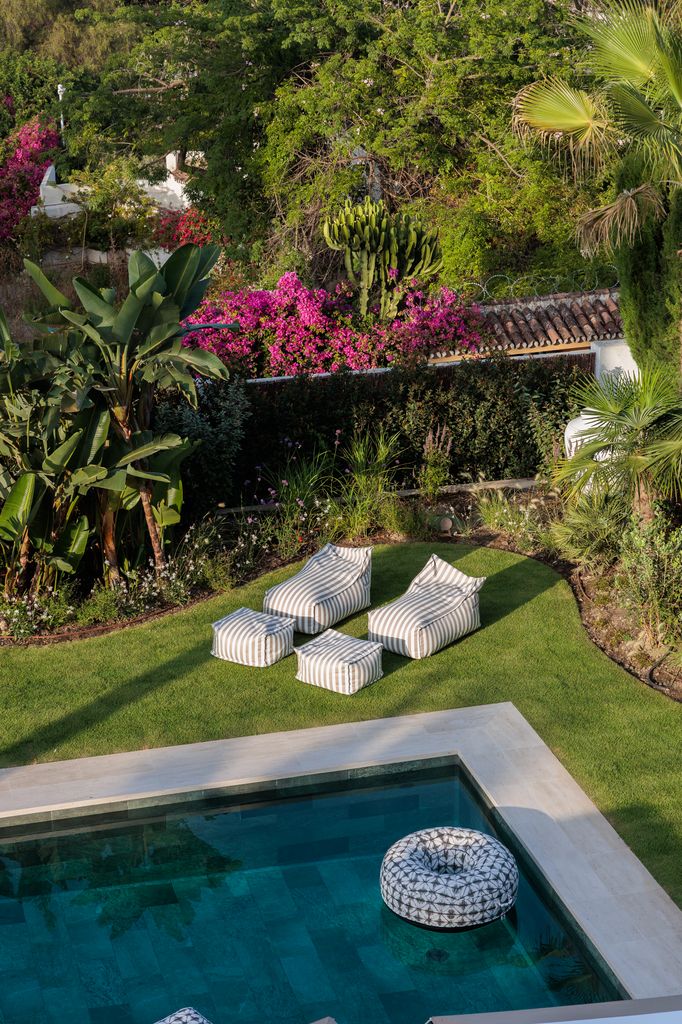 Piscina rodeada de vegetación y con una confortable zona de solárium