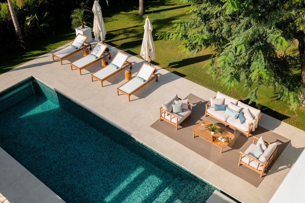 La zona de piscina está rodeada, por una parte, por solárium y salón y, por la otra, por un comedor al aire libre con cocina