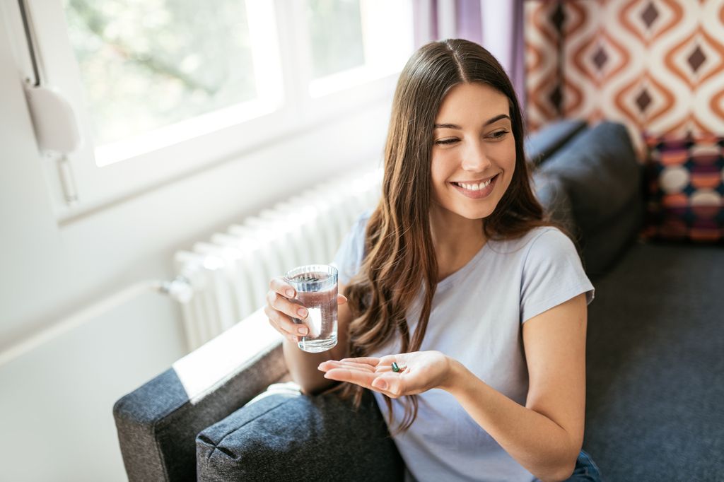 Mujer joven tomando un suplemento