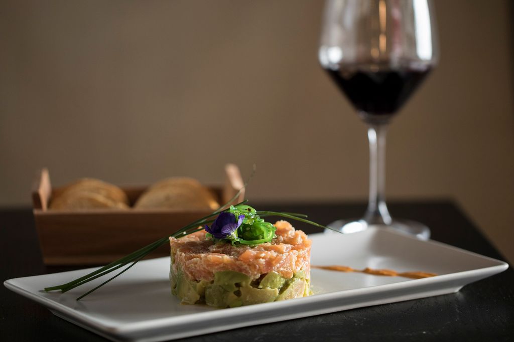 Tartar de salmón y aguacate con copa de vino tinto