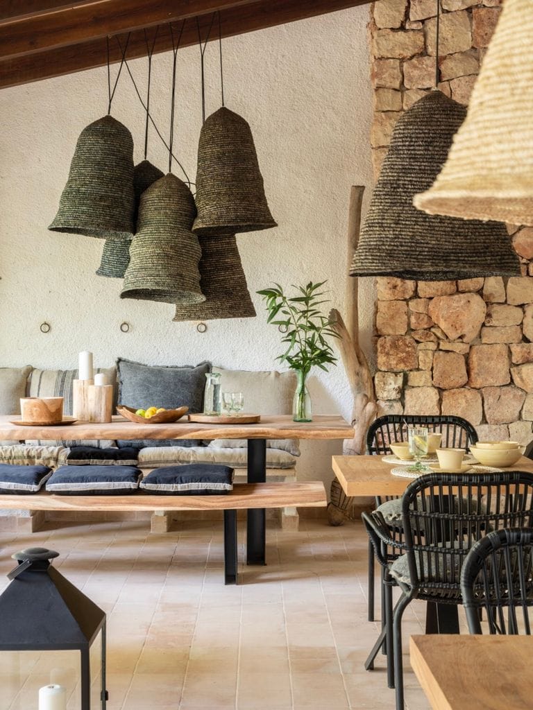 Salón de estilo rústico con pared de madera y lámparas de fibra natural. 