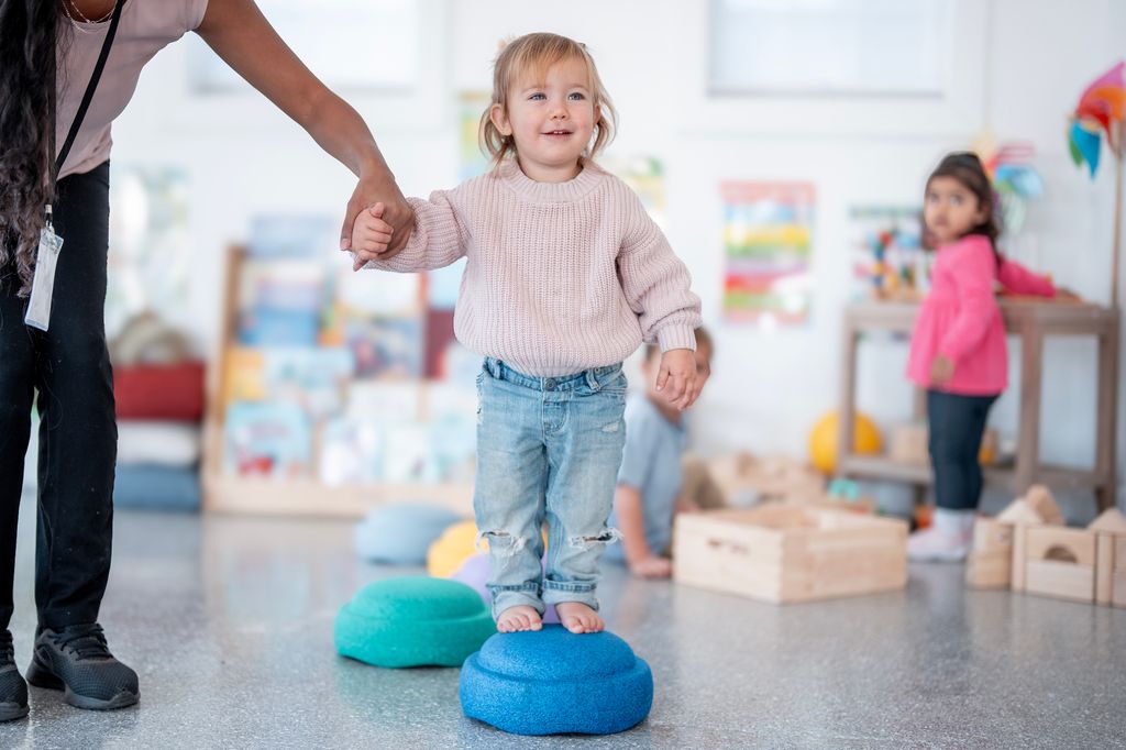 Niña pequeña sobre un objeto de equilibrio