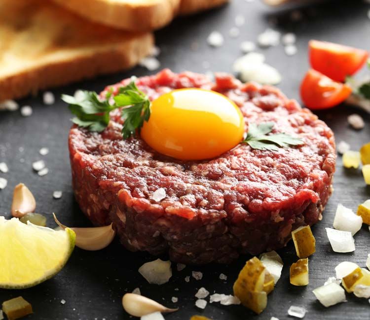Hay diferentes maneras de aliñar el steak tartar pero al más clásico no le faltan pepinilo, cebolleta, alcaparras, salsa Perrins, Tabasco, aceite de oliva, pimienta, sal y huevo.
