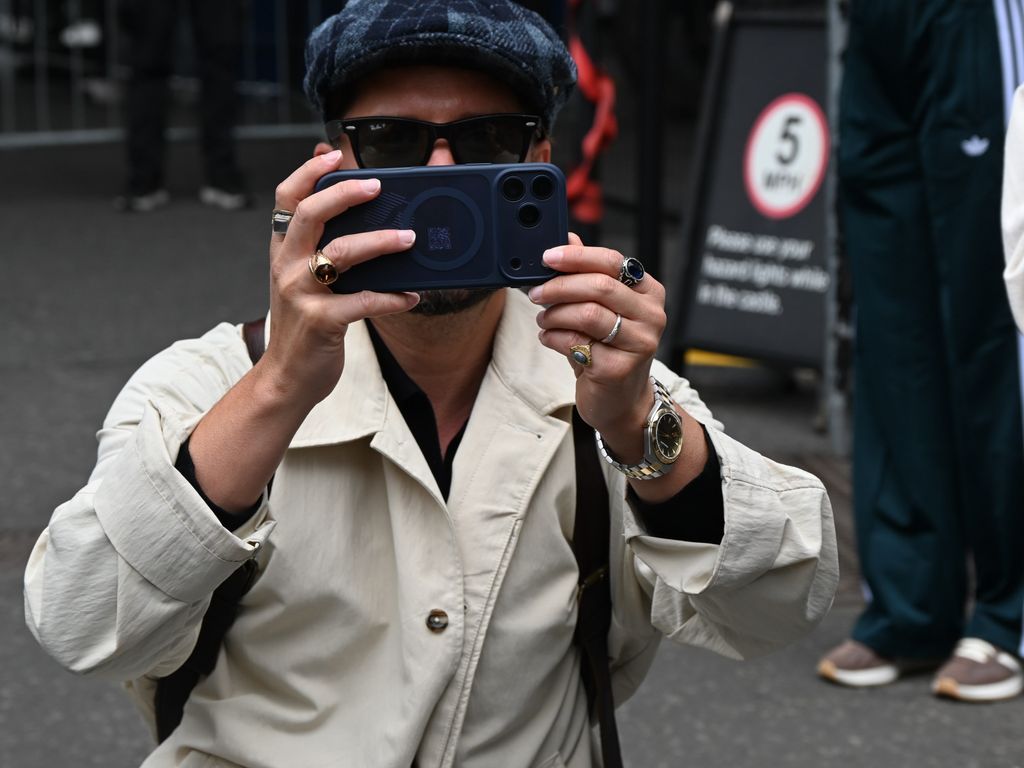 Manuel Carrasco, con boina y gabardina tomando fotos