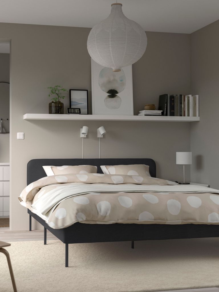 Dormitorio con balda en la pared de la cama
