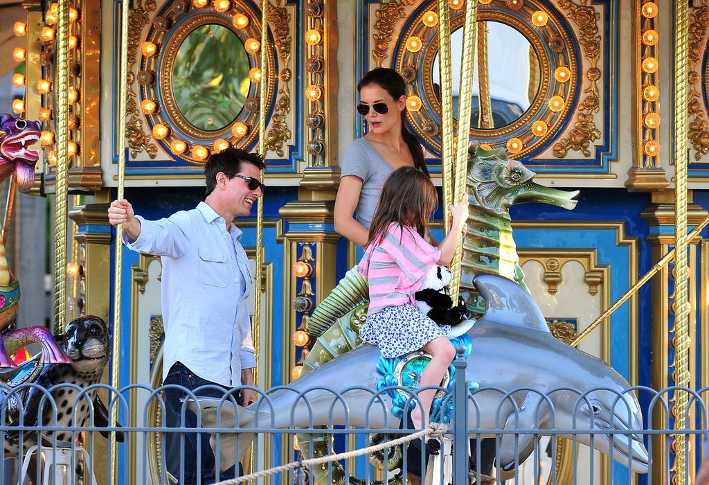 Tom Cruise y Katie Holmes con una pequeña Suri en un tiovivo 