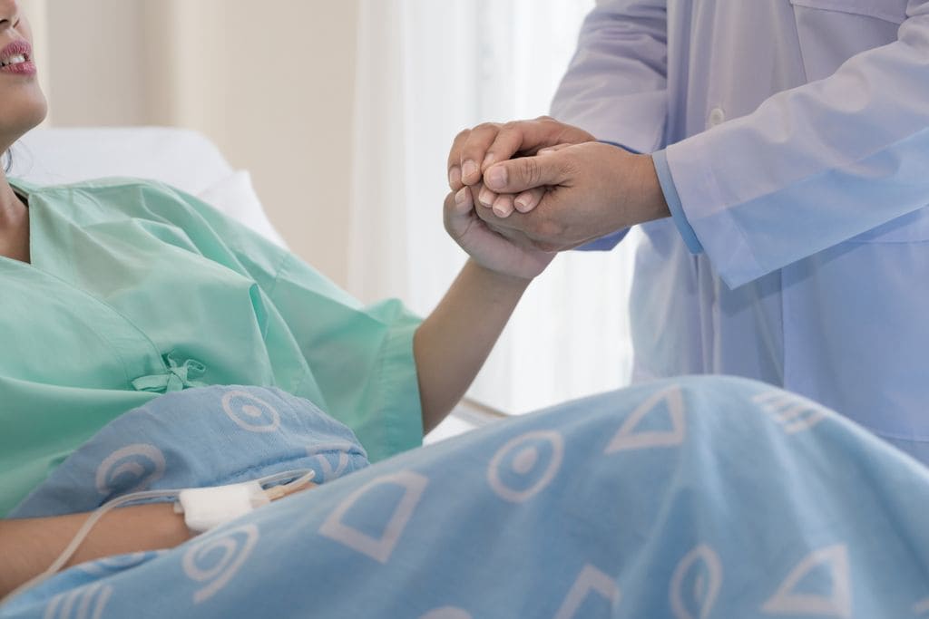 Médico dando la mano a una mujer en el hospital