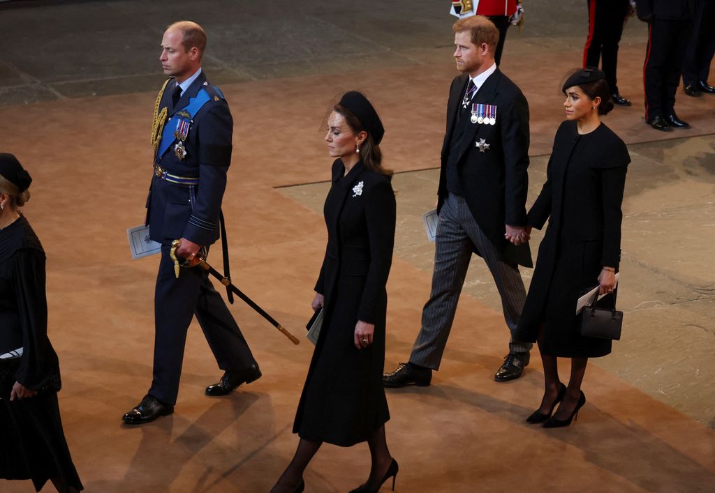 El príncipe William, la princesa Kate, el príncipe Harry y Meghan Markle, caminando en la procesión con el ataúd de la reina Isabel II a su llegada a la Abadía de Westminster, el 14 de septiembre de 2022. 