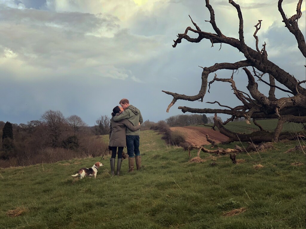 Plano general de Harry y Meghan dándose un beso en el campo en la serie de Netflix