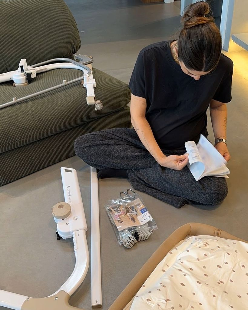 Plano medio de Marta Riumbau montando una cuna para su futuro bebé