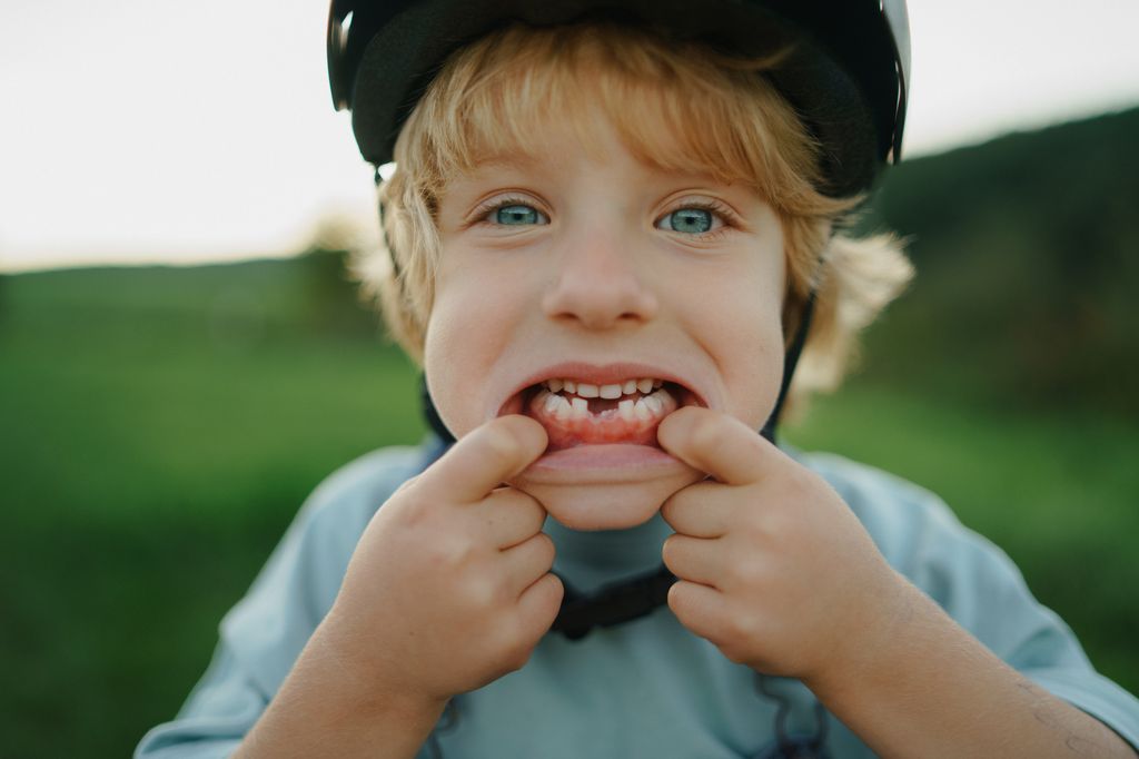 Niño al aire libre enseñando sus dientes