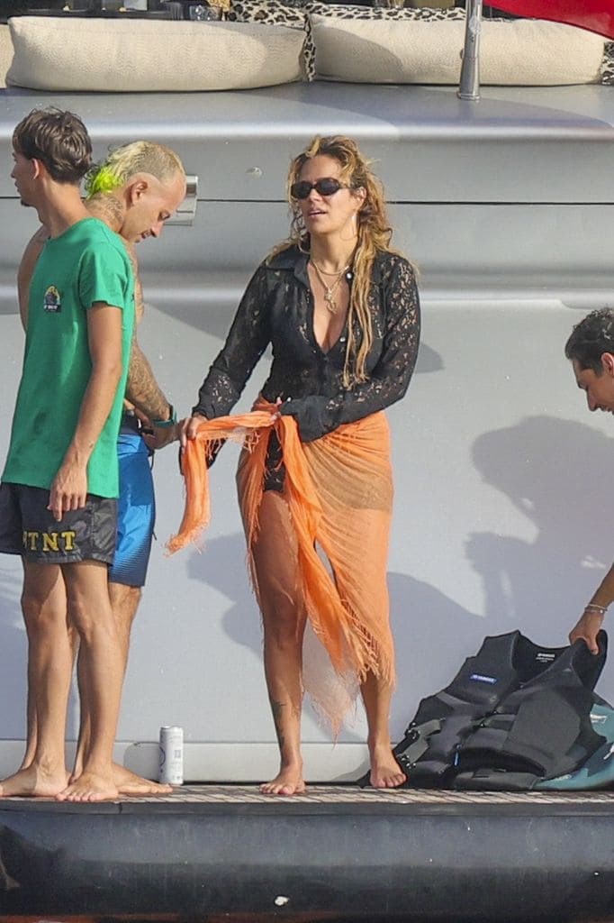 Karol G lució guapísima en un atuendo veraniego negro y naranja.