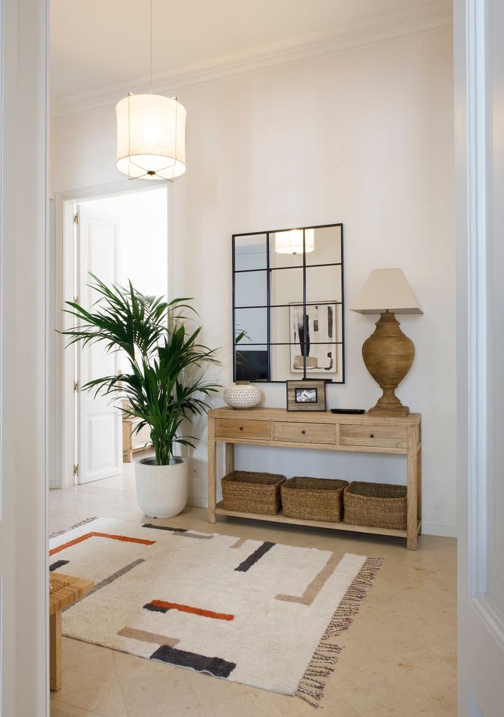 Recibidor con cestas debajo de la consola.