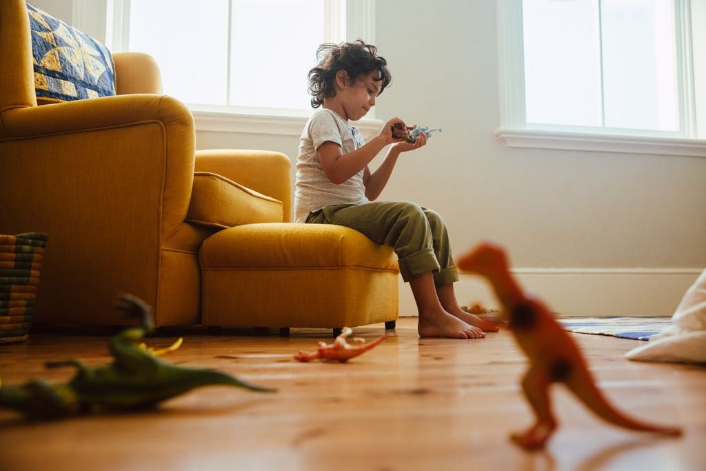 Niño pequeño jugando solo en su casa