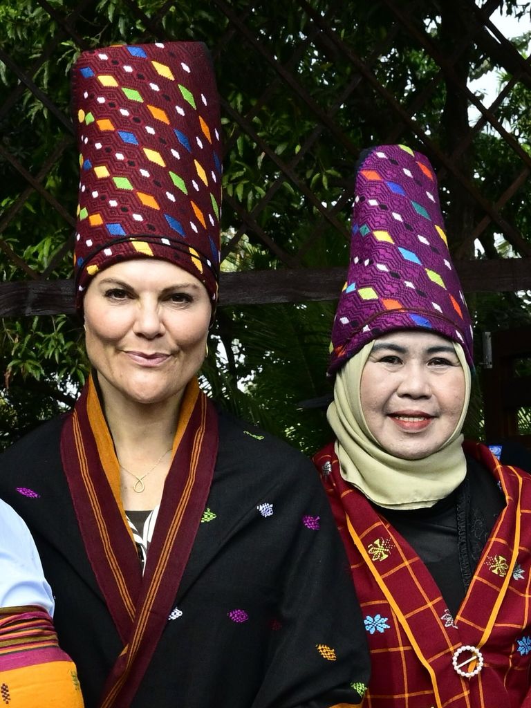 Victoria de Suecia con uno de los vistosos tocados regionales de Indonesia