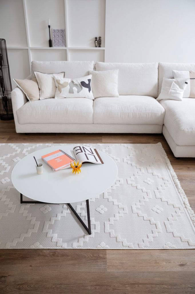Salón con sofá, mesa de centro y alfombra de color blanco