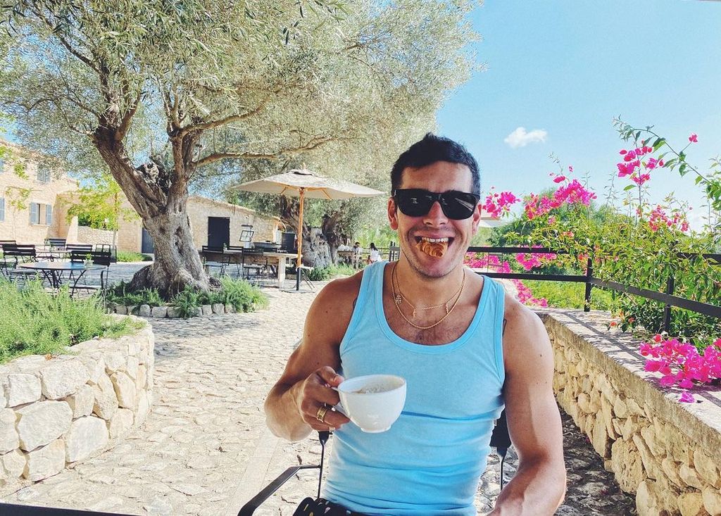 Plano medio de Mario Casas desayunando al aire libre