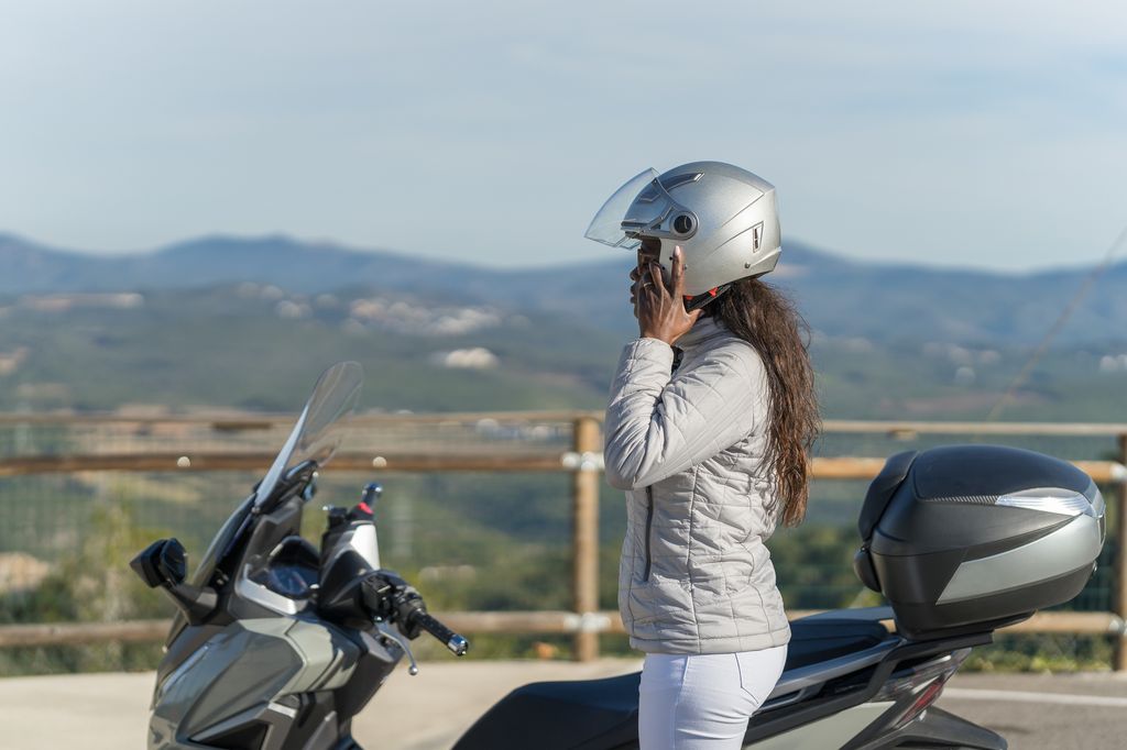 Una chica poniéndose el casco de su moto