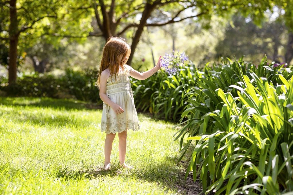Lilibet lució adorable jugando descalza en el jardín.