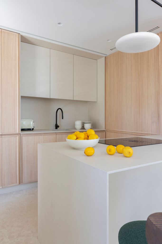 Cocina con muebles de madera clara y color crema