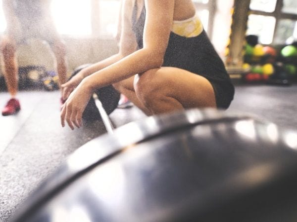 Mujer levanta pesa en el gimnasio