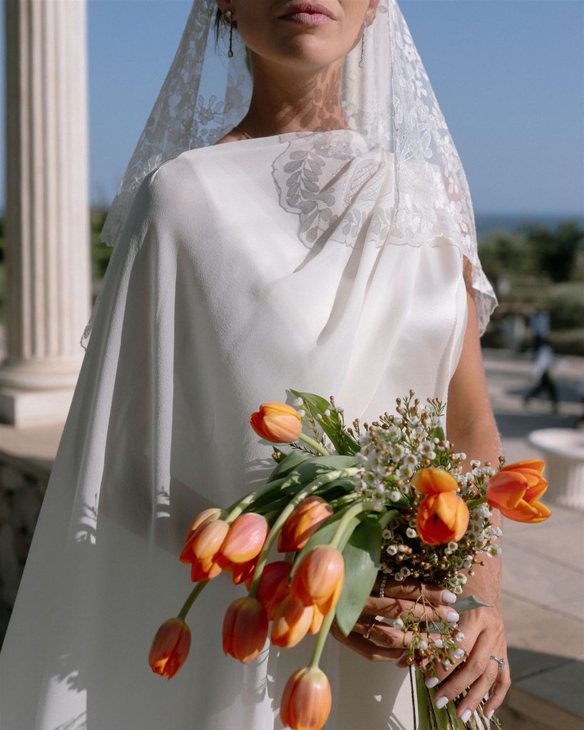 Vestido de novia de Carla, de Claudia Llagostera con ramo de flores de tulipanes de Jardín del Cabo