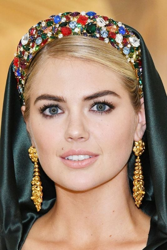 Kate Upton con vestido verde con capucha y corona de piedras 