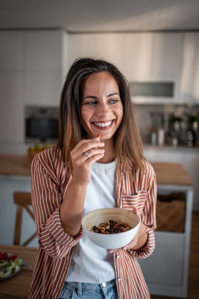 Una mujer comiendo frutos secos