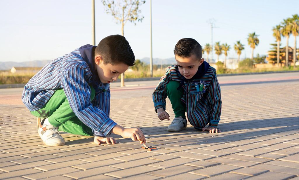 Two valencian brothers wearing a valencian fallas dress and playing with firecrackers