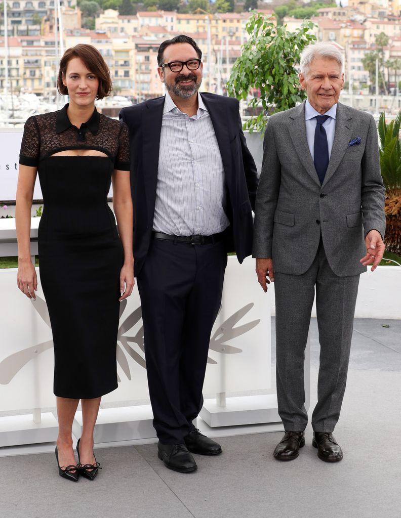 Phoebe Waller-Bridge, James Mangold y Harrison Ford posan juntos en un evento formal.
